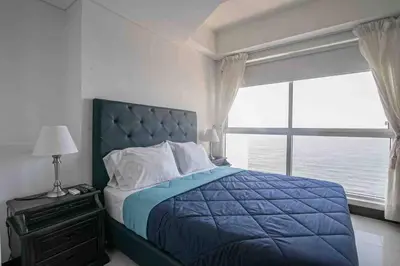 a bedroom with a blue bed with a large window at Apartamento Bocagrande Vista al Mar Piso 21 in Cartagena de Indias