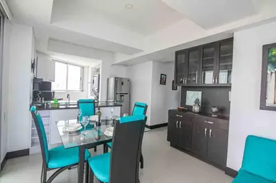 a kitchen with a glass table and blue chairs at Apartamento Bocagrande Vista al Mar Piso 21 in Cartagena de Indias