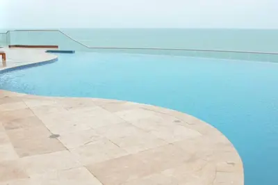 a swimming pool with blue water and a bench at Apartamento Bocagrande Vista al Mar Piso 21 in Cartagena de Indias