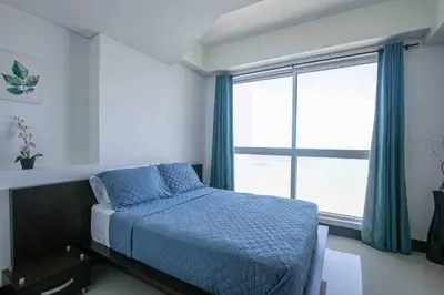 a bedroom with a bed and a large window at Apartamento Bocagrande Vista al Mar Piso 31 in Cartagena de Indias