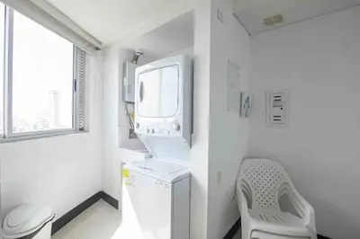 a small white kitchen with a washing machine and a window at Apartamento Bocagrande Vista al Mar Piso 31 in Cartagena de Indias