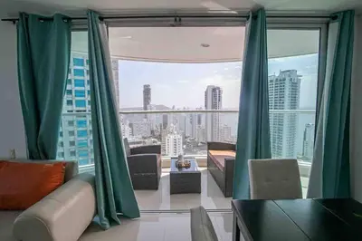 a living room with a large window with green curtains at Apartamento Bocagrande Vista al Mar Piso 31 in Cartagena de Indias