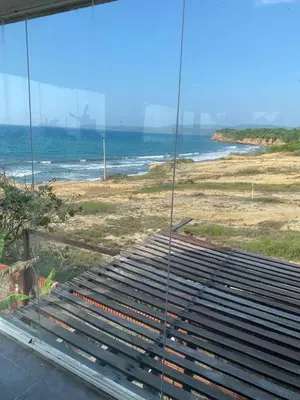 a view of the ocean from a glass building at Villa frente al Mar cerca a Barranquilla in Tubará