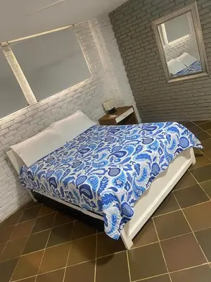 a bedroom with a bed with a blue and white comforter at Villa frente al Mar cerca a Barranquilla in Tubará
