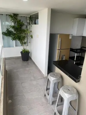 a kitchen with two stools and a black counter top at Villa frente al Mar cerca a Barranquilla in Tubará