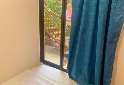a window with a blue curtain in a room at Hostal Cartagonova - Habitaciones privadas y amplias cerca a zonas turísticas in Cartagena de Indias