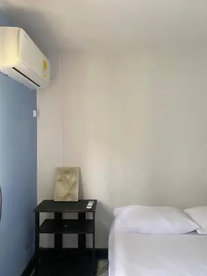 a bedroom with two beds and a table with a bag on it at Hotel Villa Mary Apartaestudios playa in Puerto Colombia