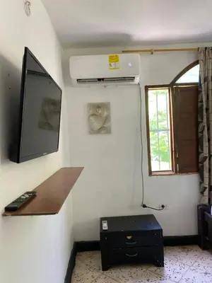 a room with a wall with a tv and a table at Hotel Villa Mary Apartaestudios playa in Puerto Colombia