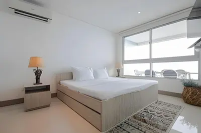 a bedroom with a bed and a large window at Laurdhomes Lujoso Apto Piso 28 frente al mar, 2BTH in Cartagena de Indias