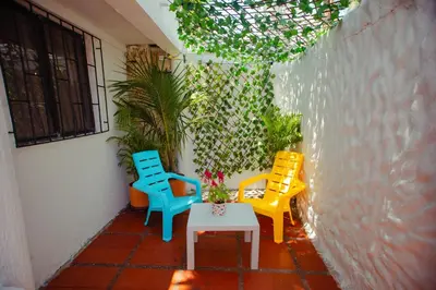 three chairs and a table on a patio at Casa Hotel Marbella Beach in Cartagena de Indias
