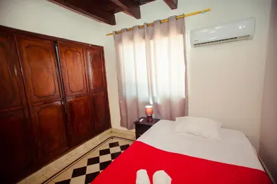 a bedroom with a red and white bed and a window at Casa Hotel Marbella Beach in Cartagena de Indias