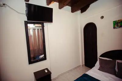 a bedroom with a bed and a television on the wall at Casa Hotel Marbella Beach in Cartagena de Indias