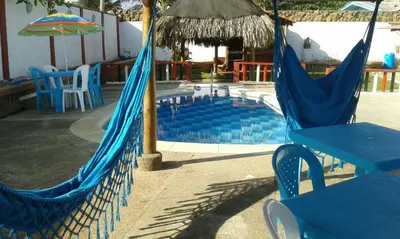 a pool with two hammocks and a table and chairs at Phandy in Santa Veronica