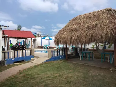 a resort with a swimming pool and a straw hut at Phandy in Santa Veronica
