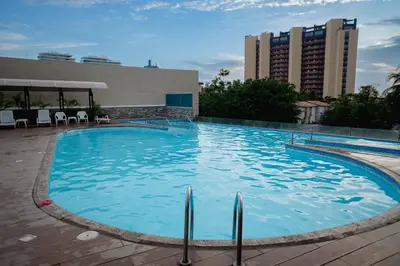 a large blue swimming pool with buildings in the background at Hermoso apartamento. Cerca del mar. in Santa Marta