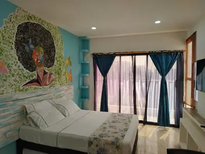a bedroom with a bed with a painting on the wall at Avadia del Mar in Cartagena de Indias