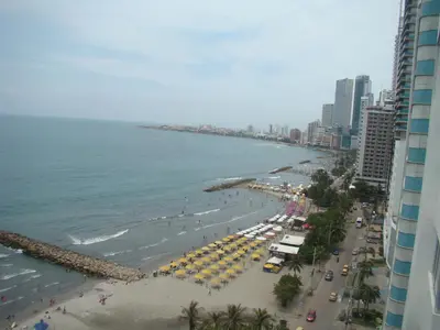 a view of a beach with umbrellas and the ocean at Apartamento , vista a la ciudad antigua y playa in Cartagena de Indias