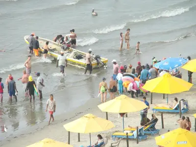 a crowd of people on a beach with a surfboard at Apartamento , vista a la ciudad antigua y playa in Cartagena de Indias