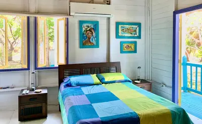 a bedroom with a bed with a colorful blanket at Casita Caribe en reserva natural, playa privada, kayaks, wifi, aire acondicionado in San Onofre