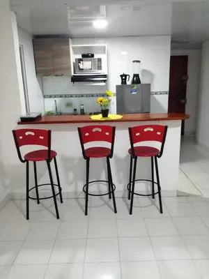 a kitchen with two red bar stools and a counter at Acogedor apartamento en Cartagena in Cartagena de Indias