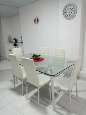 a dining room with a glass table and white chairs at Acogedor apartamento en Cartagena in Cartagena de Indias