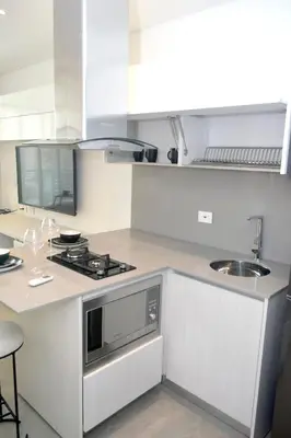 a white kitchen with a stove and a sink at Las Margaritas, Loft en Distrito 90 in Barranquilla
