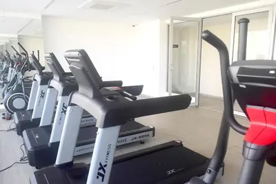 a gym with a row of cardio machines at Las Margaritas, Loft en Distrito 90 in Barranquilla