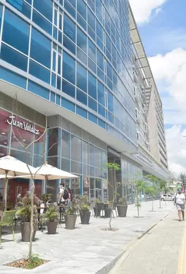 a large glass building with people sitting outside of it at Las Margaritas, Loft en Distrito 90 in Barranquilla
