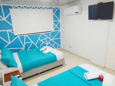 a bedroom with two beds and a blank screen at APT cercano centro Histórico N - Marbella O in Cartagena de Indias