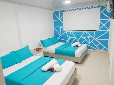 a bedroom with two beds and a blank screen at APT cercano centro Histórico N - Marbella O in Cartagena de Indias
