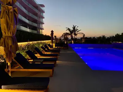 a row of lounge chairs next to a swimming pool at !Condominio de Lujo! Playa + Piscinas + Natural in Cartagena de Indias