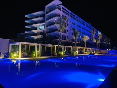 a large building with a swimming pool at night at Amazing Loft / Private Beach + Pools + Natural in Cartagena de Indias