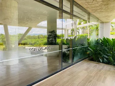 a lobby with glass walls and plants in a building at Amazing Loft / Private Beach + Pools + Natural in Cartagena de Indias