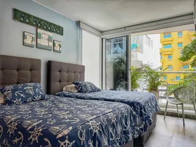 a bedroom with two beds and a large window at ¡Amazing Beach Dúplex! Infinity Pool / Rooftop in Cartagena de Indias
