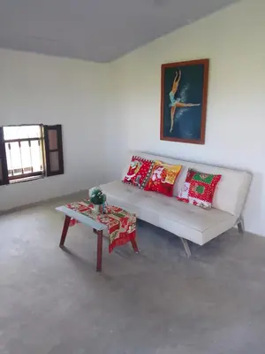 a living room with a white couch and a table at Apart Cabaña KTIK in San Bernardo del Viento