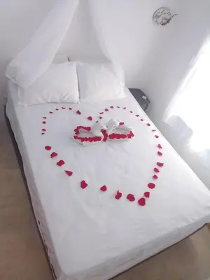a white bed with a heart made out of red hearts at Apart Cabaña KTIK in San Bernardo del Viento