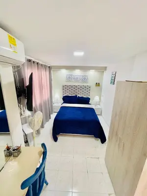 a bedroom with a blue bed and a table at Hostal Casa Dandy in Cartagena de Indias