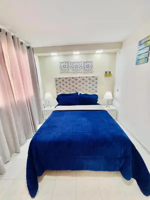 a bedroom with a large blue bed with blue pillows at Hostal Casa Dandy in Cartagena de Indias