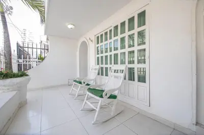 a white porch with white chairs and a staircase at Apartamento en Casa Dandy in Cartagena de Indias