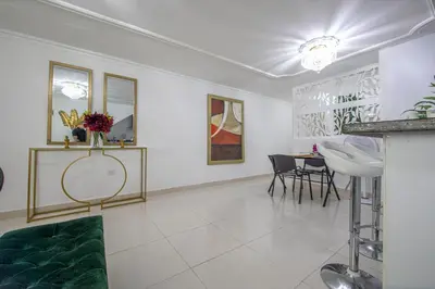 a living room with white walls and a table and chairs at Apartamento en Casa Dandy in Cartagena de Indias