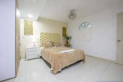 a bedroom with a large bed in a white room at Apartamento en Casa Dandy in Cartagena de Indias