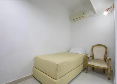 a bed and a chair in a room at Apartamento en Casa Dandy in Cartagena de Indias