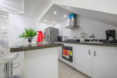 a kitchen with white cabinets and a counter top at Apartamento en Casa Dandy in Cartagena de Indias