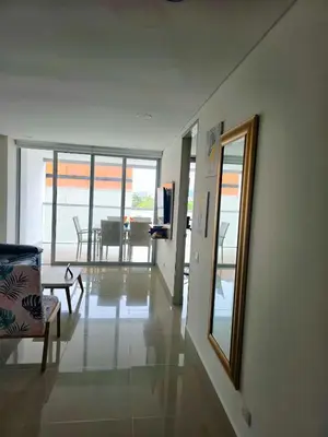 a living room with a mirror and a chair and a table at AZ Apartments in Cartagena de Indias