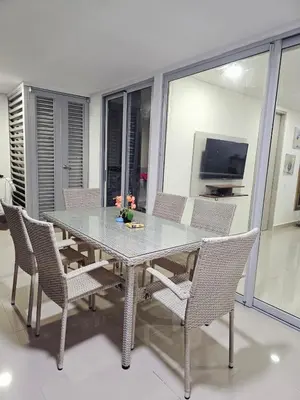 a dining room table with chairs and a television at AZ Apartments in Cartagena de Indias