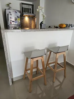 a bar with two stools and a counter with a refrigerator at AZ Apartments in Cartagena de Indias