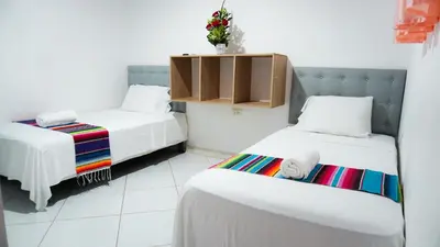 a small room with two beds and a cabinet at Hotel Playa Divina in Coveñas