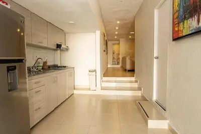 a large kitchen with white cabinets and a hallway at Casa Badillo 3 4br LUXURY ROOFTOP oldcity AC jacuzzi hottub wifi in Cartagena de Indias