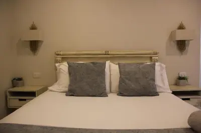 a bedroom with a white bed with two pillows at Casa Badillo 3 4br LUXURY ROOFTOP oldcity AC jacuzzi hottub wifi in Cartagena de Indias