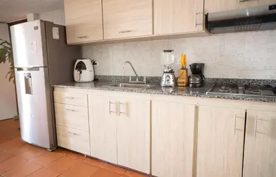 a kitchen with wooden cabinets and a white refrigerator at Casa Badillo 3 4br LUXURY ROOFTOP oldcity AC jacuzzi hottub wifi in Cartagena de Indias